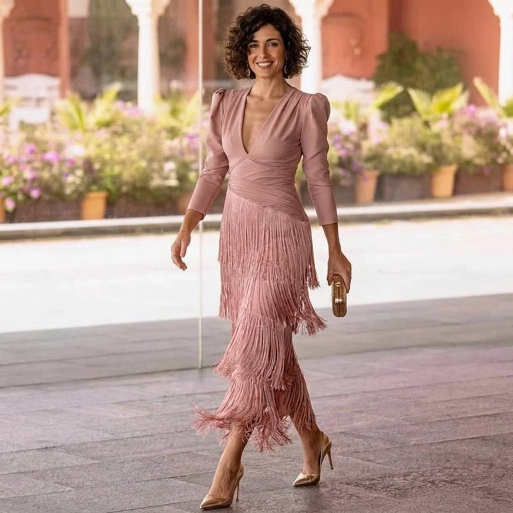 a woman wearing a pink dress with tassles