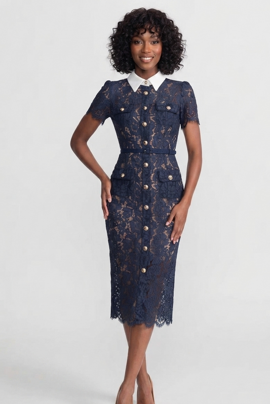 A woman modeling a navy blue lace midi dress with a white pointed collar and gold-tone buttons, set against a plain light gray studio background.