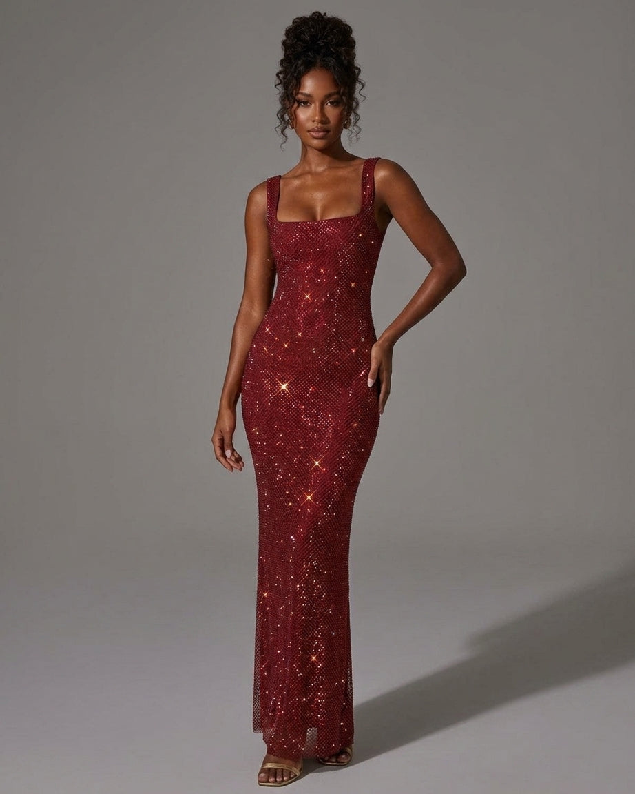A woman modeling a floor-length, sleeveless burgundy sequined gown with a square neckline and fitted silhouette against a plain gray studio background.