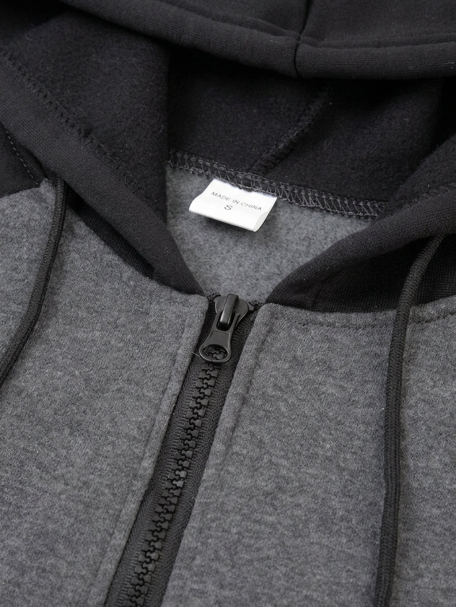 Close-up of a zip-up hoodie with a heather gray front body, black hood and zipper trim, and a small white interior label.