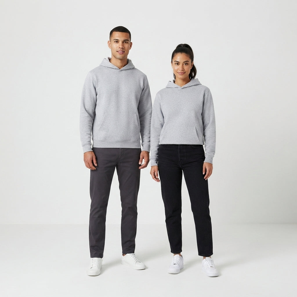 A man and a woman modeling matching light gray hoodies, standing against a clean white studio background. The man wears dark gray pants and white sneakers, while the woman wears black pants and white sneakers.