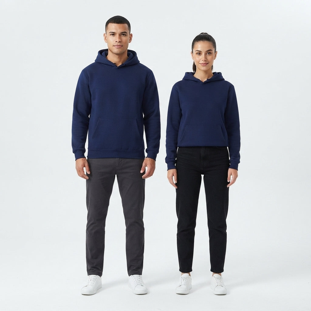 A man and a woman modeling matching navy blue hooded sweatshirts against a clean white studio background. The man wears dark gray pants and white sneakers, while the woman wears black pants and white sneakers.