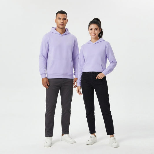A man and a woman modeling matching light purple hoodies, with the man wearing dark gray pants and the woman wearing black pants, standing against a plain white studio background.