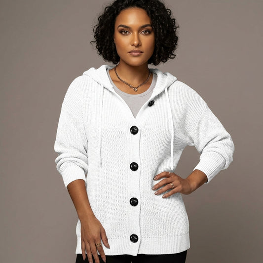 A woman modeling a white textured hooded cardigan with black buttons, worn over a light gray top, against a solid taupe background.