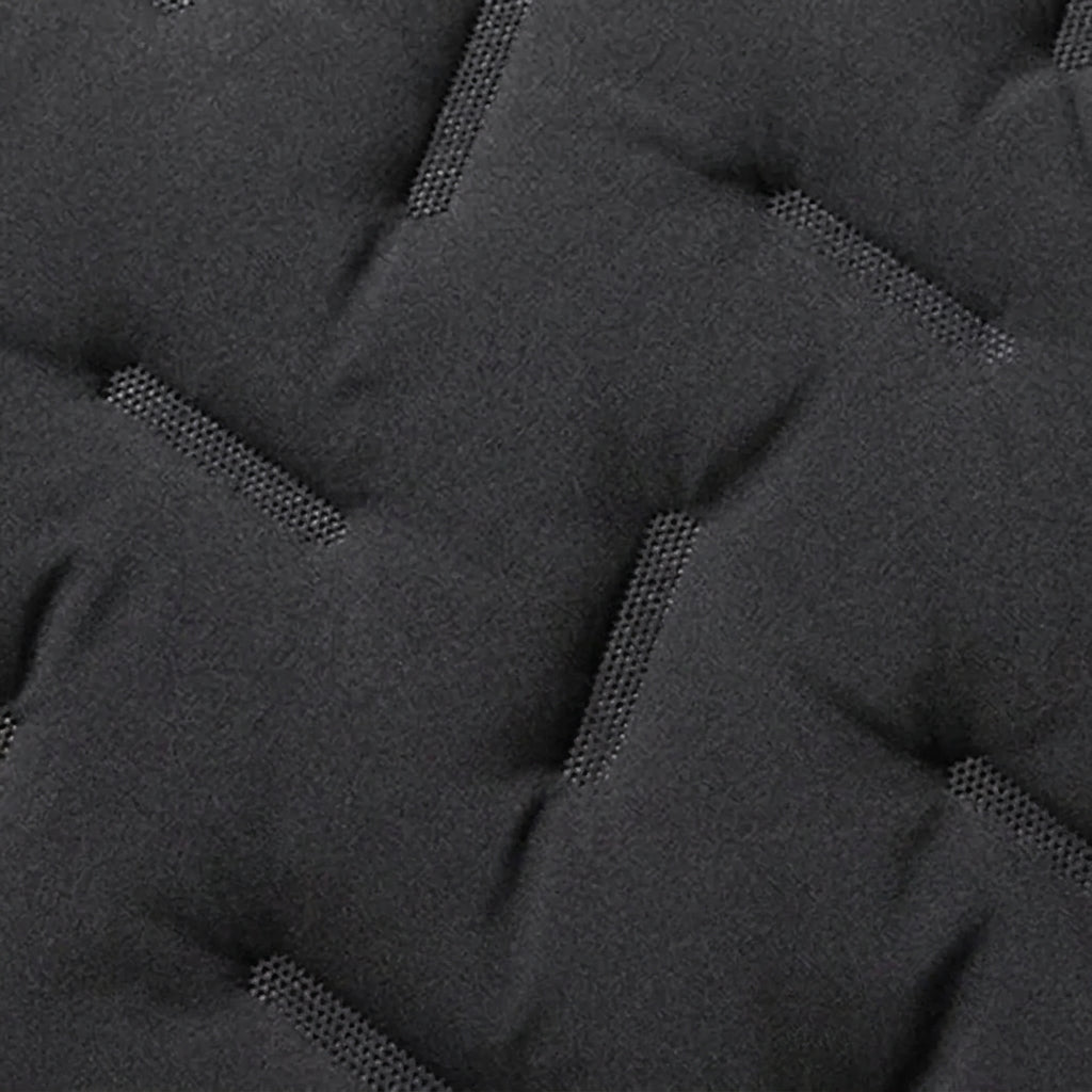 Close-up of a dark gray quilted fabric with tufted stitching and a textured woven pattern.