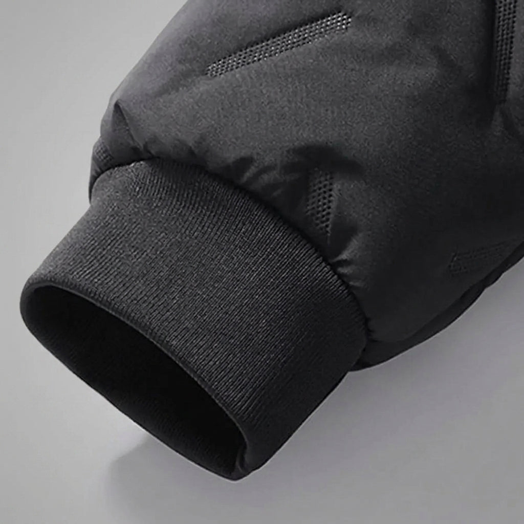 Close-up detail of a black puffer jacket sleeve showing the ribbed knit cuff and quilted fabric texture.