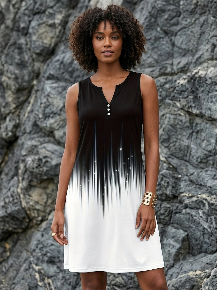 A woman wearing a sleeveless black and white ombre dress with a V-neck and three buttons, standing in front of a gray rocky cliff background.