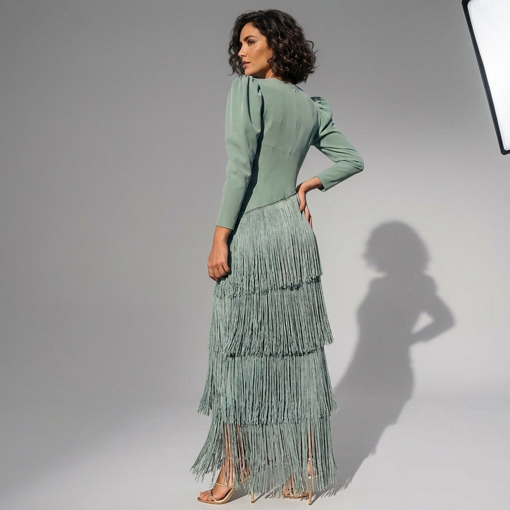 a woman wearing a green dress with tassles