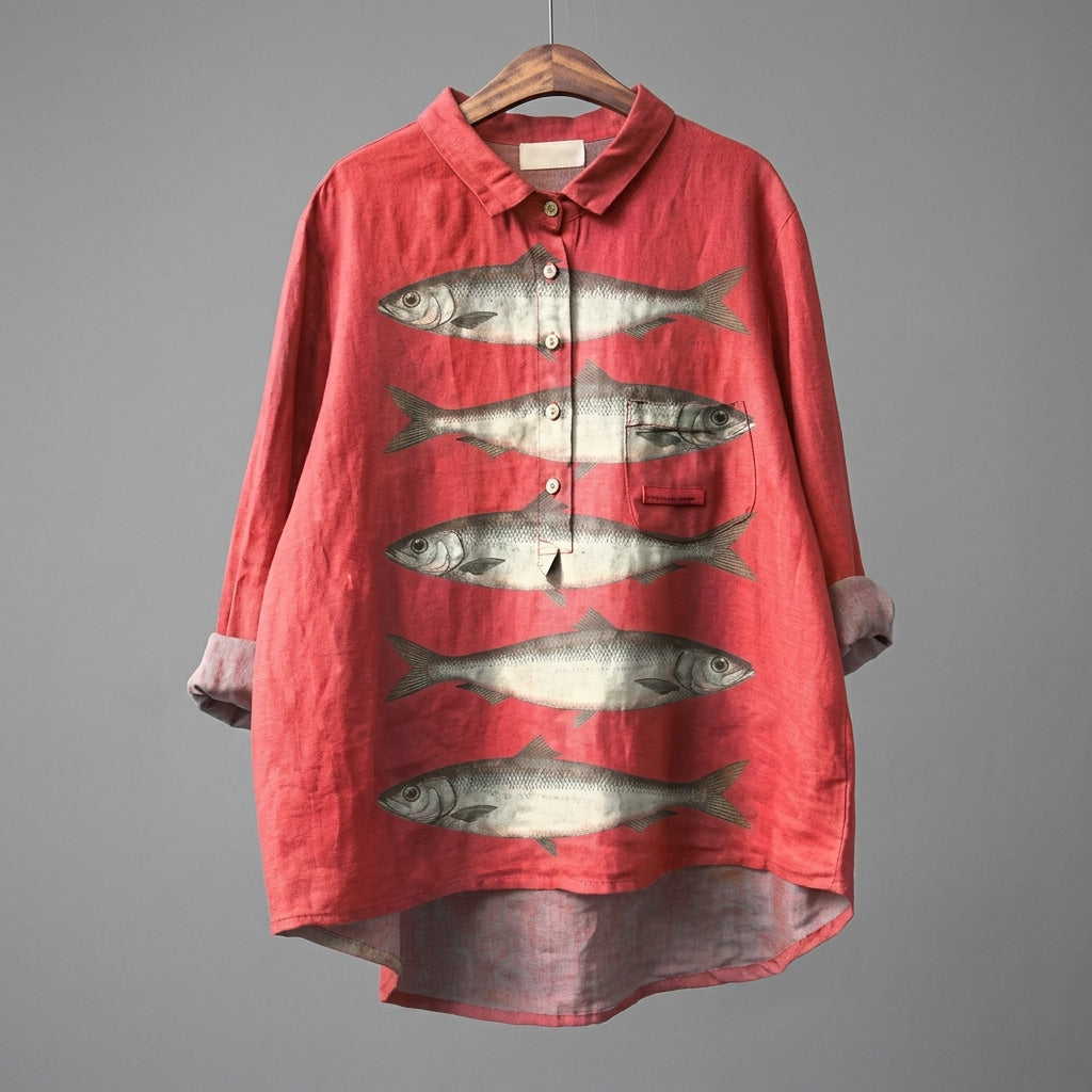 A red linen button-up shirt with a collar, featuring a graphic print of five horizontal fish on the front. The shirt is shown hanging on a wooden hanger against a solid gray background.