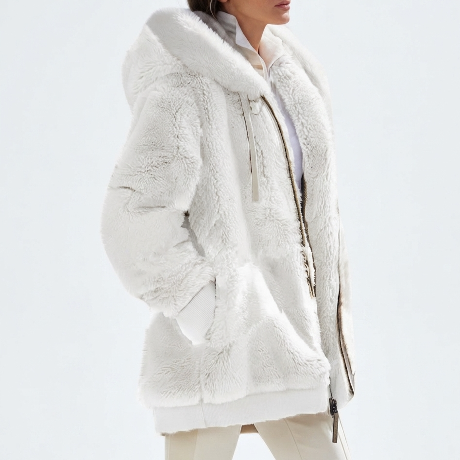 A model wearing a plush white faux-fur hooded jacket with a white shirt and cream pants, shown from the side against a clean white studio background.