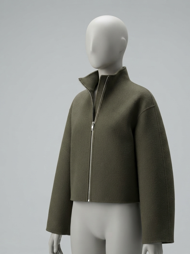 An olive green cropped jacket with a high stand-up collar and front zipper, displayed on a matte gray mannequin against a light gray studio background.