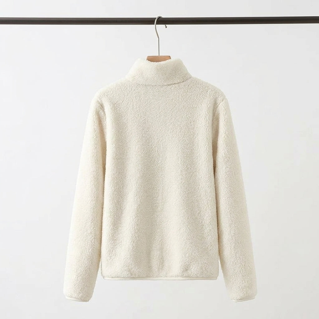 An off-white sherpa fleece mock-neck sweater hanging on a wooden hanger from a black clothing rack, set against a plain white background.