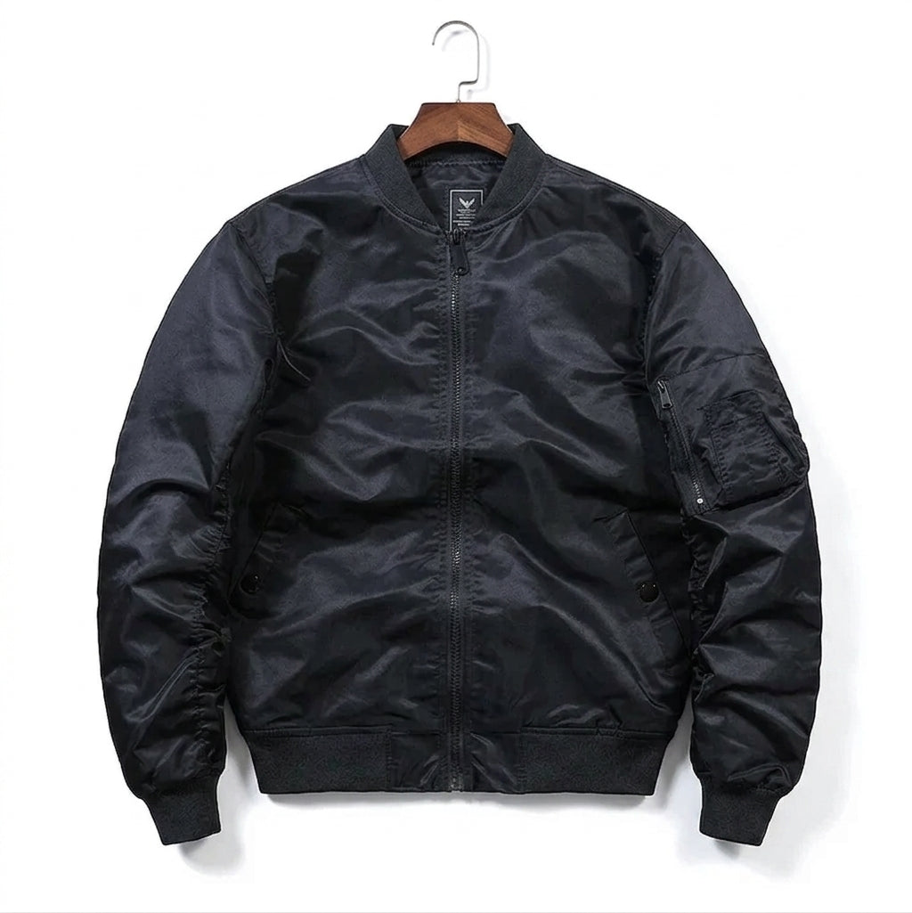A black nylon MA-1 style bomber jacket hanging on a wooden hanger against a plain white background.