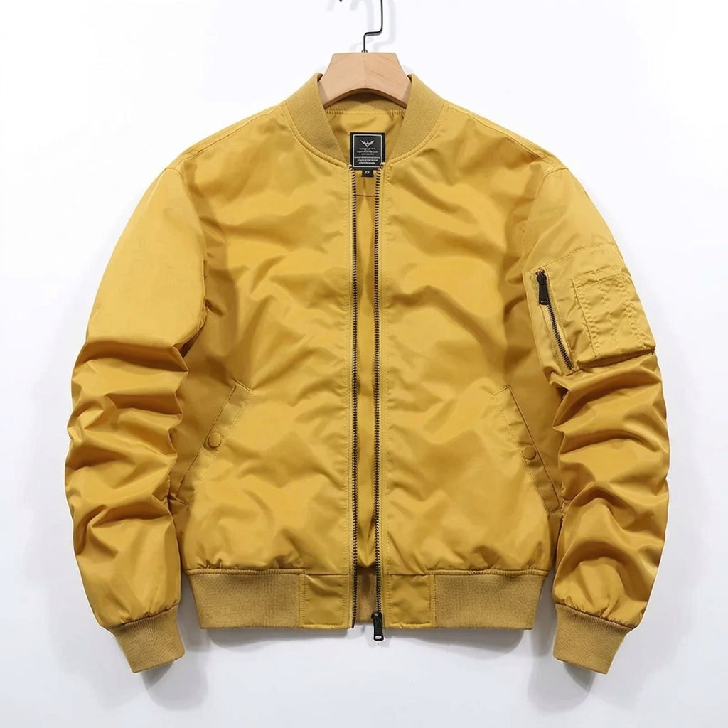 A mustard yellow nylon bomber jacket hanging on a wooden hanger against a plain white background.