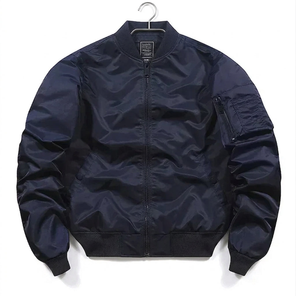 A dark navy blue nylon bomber jacket with a full zip front, ribbed collar, cuffs, and hem, hanging on a black hanger against a white background.