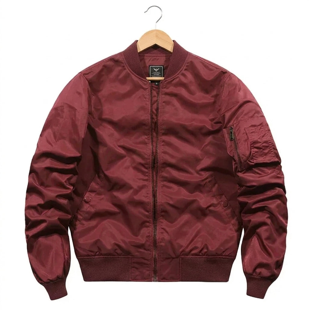 A maroon satin bomber jacket hanging on a wooden hanger against a plain white background.
