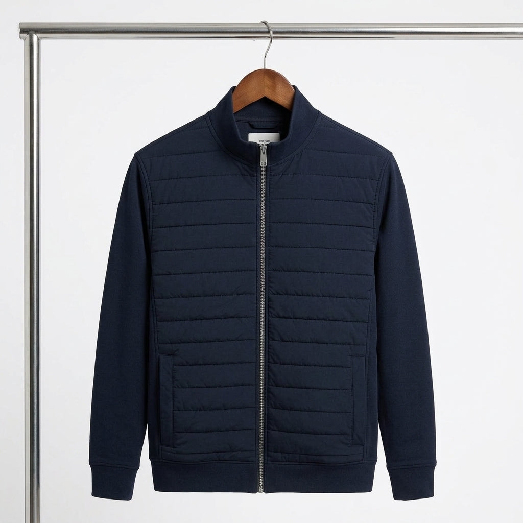 A navy blue quilted zip-up jacket hanging on a wooden hanger from a metal clothing rack, shown against a clean white background.