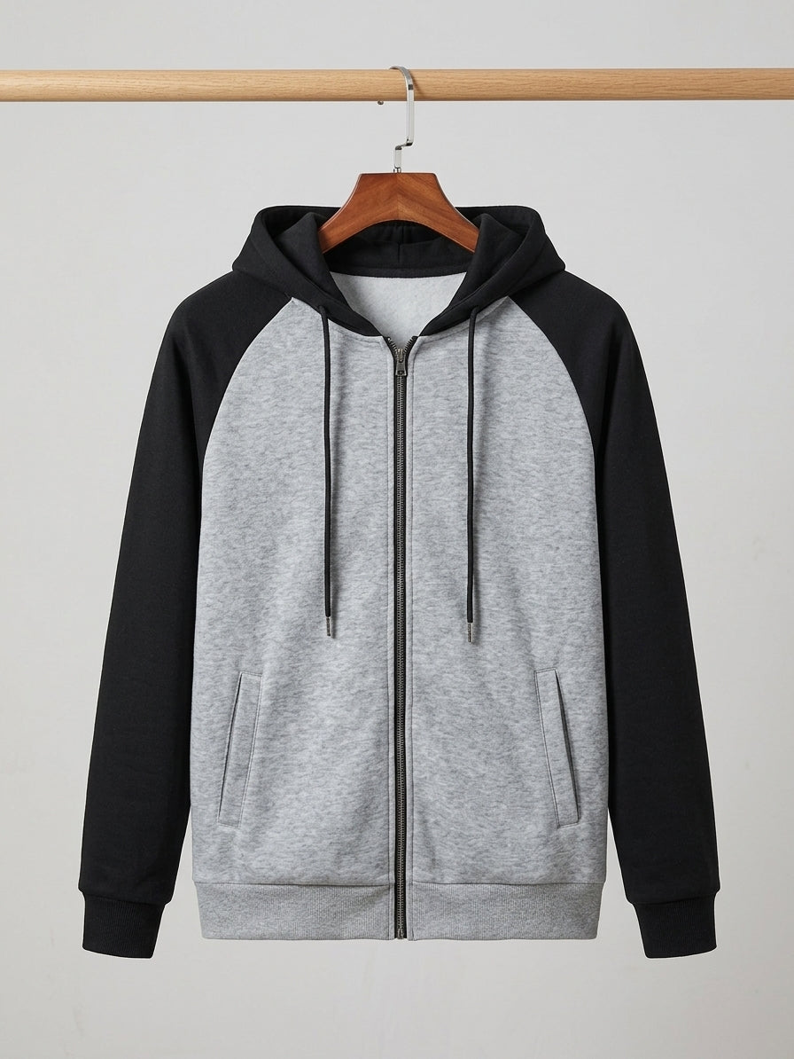 A gray and black raglan zip-up hoodie hanging on a wooden hanger against a light gray background.