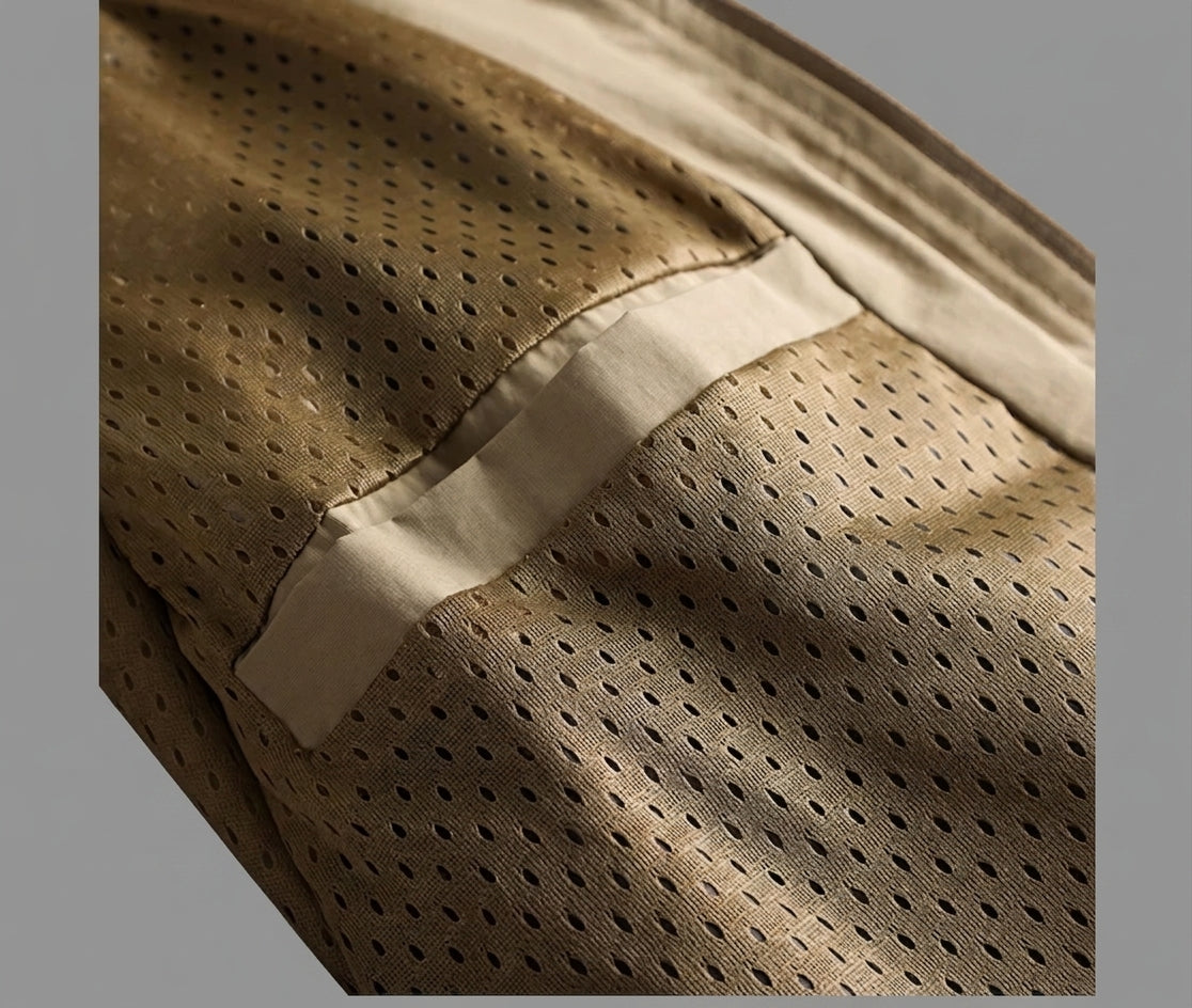 Close-up of a beige perforated mesh fabric with a smooth beige trim band, shown against a neutral gray background.