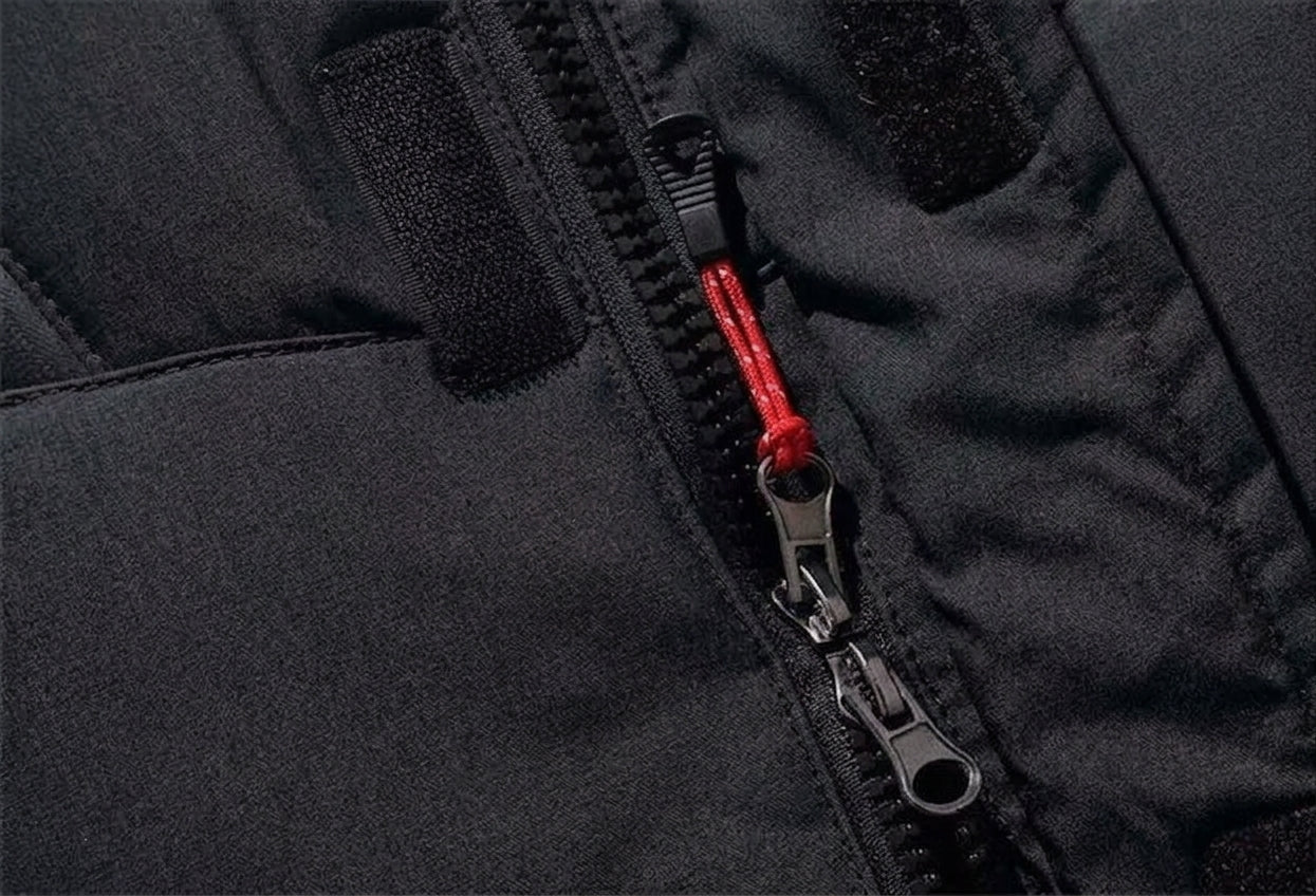 Close-up of a black jacket or puffer panel with a black zipper and a bright red zipper pull cord.