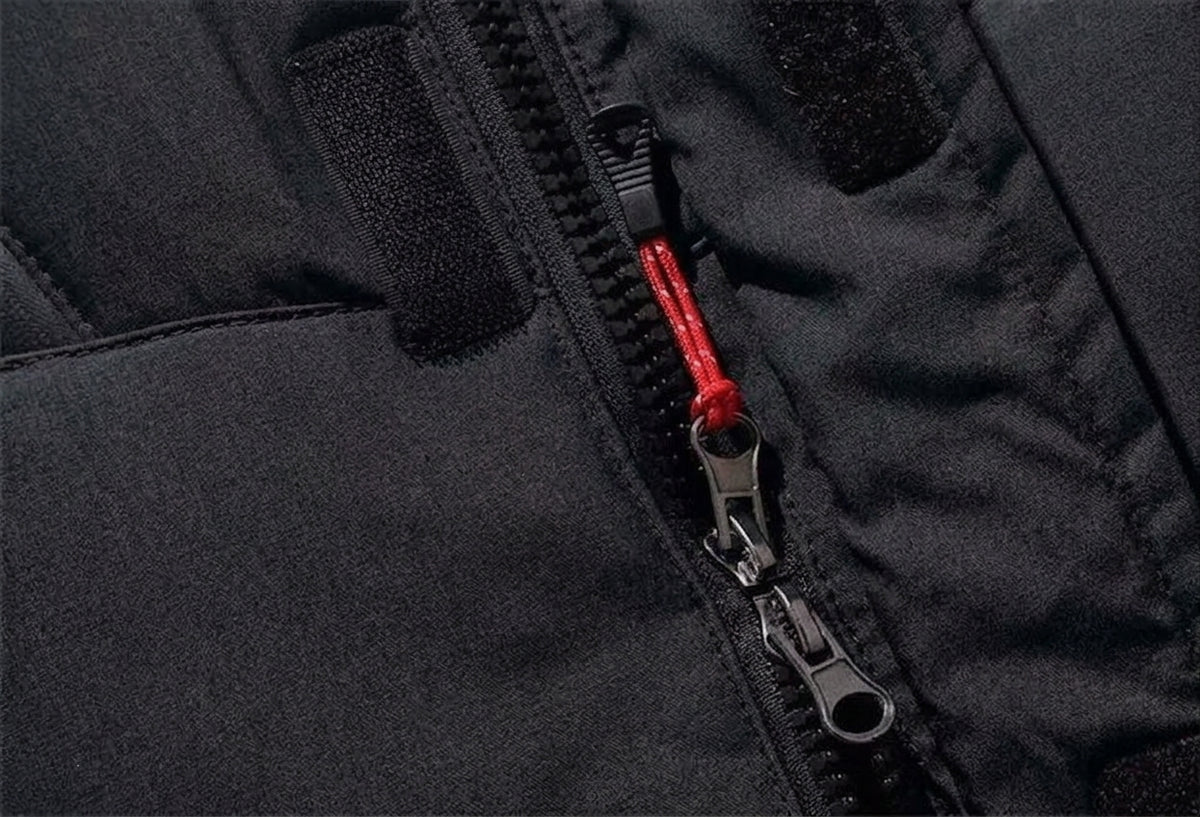 Close-up of a black jacket or puffer panel with a black zipper and a bright red zipper pull cord.
