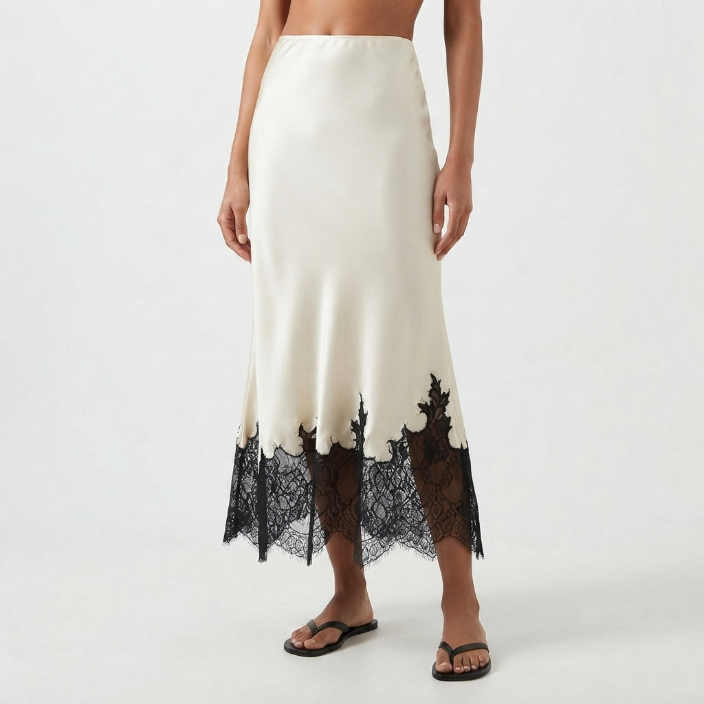 An off-white satin midi skirt with a black lace hem, shown on a model wearing black flip-flops against a light gray studio background.