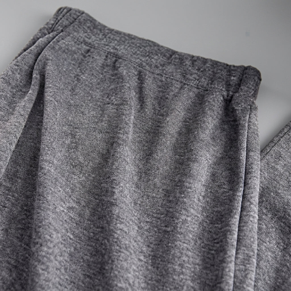 Close-up of a pair of heather gray sweatpants showing the fabric texture and waistband details.