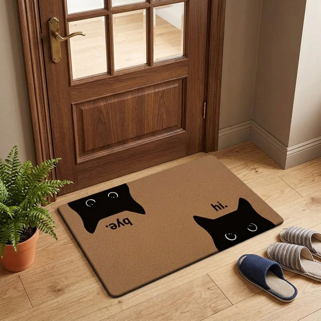 Doormat with cat designs and text 'hi' and 'bye' on a wooden floor in front of a door.